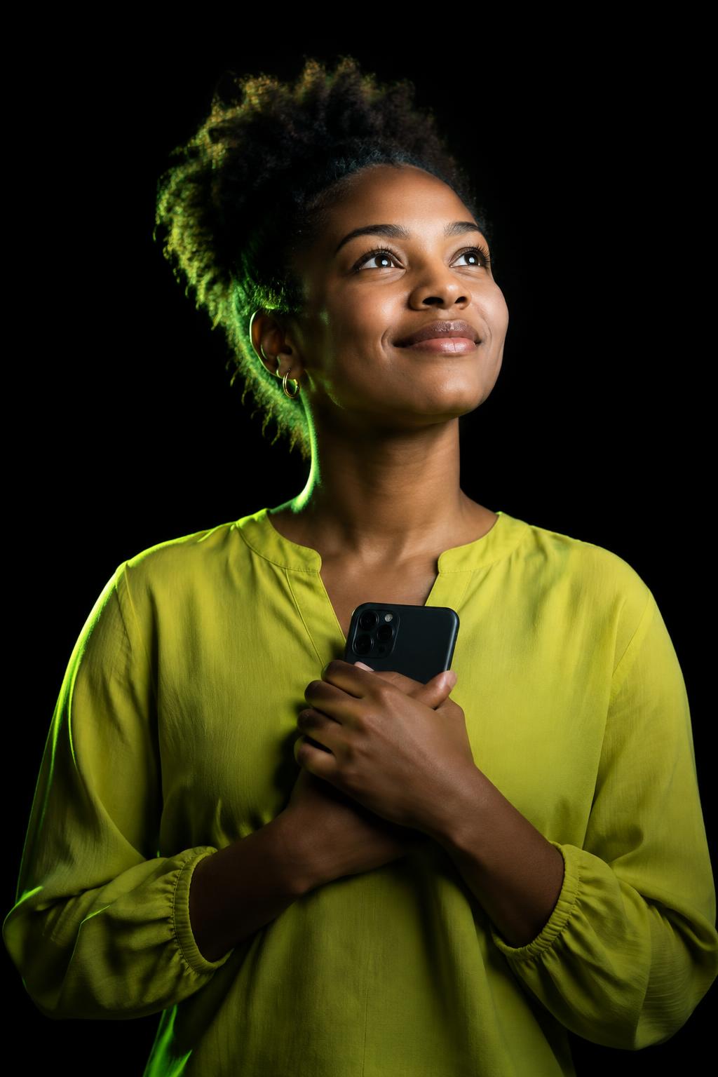 Une jeune femme pleine d’espoir tenant son téléphone, photo illustrative